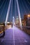 Pedestrians on a white bridge above the River Thames during nighttime