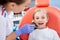 Pediatric dentist checks caries in a little girl. beautiful girl is smiling in dentist`s office. concept is a children`s medical