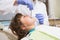 Pediatric dentist examining a little boys teeth in the dentists chair