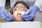 Pediatric dentist examining a little boys teeth in the dentists chair