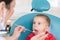 Pediatric dentist examining a little boys teeth in the dentists chair at the dental clinic. Dentist examining little boy& x27;s