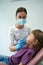 Pediatric dentist examining teeth of little girl