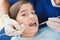 Pediatric dentist using dental explorer and angled mirror