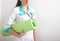 Pediatric physiotherapist and rehabilitation doctor stands with a green carpet for gymnastics on a white background. The