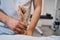 Pediatric physiotherapist in uniform checks girls arm on massage bed closeup. Professional therapist