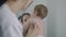 Pediatrician applies stethoscope to back of baby