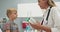 Pediatrician checks temperature of sick boy with fever using a thermometer