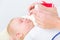 Pediatrician clearing the nose of a baby by applying saline solution