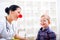 Pediatrician with clown nose and happy child patient