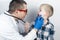 A pediatrician examines a boy who complains of a sore throat. Diagnosis of tracheal diseases. Angina, tonsillitis, pharyngitis,