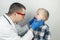 A pediatrician examines a boy who complains of a sore throat. Diagnosis of tracheal diseases. Angina, tonsillitis, pharyngitis,