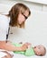 Pediatrician examines a newborn baby with a spatula