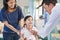 Pediatrician examining little girl , her mother beside her