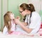Pediatrician examining little girls throat