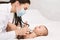 Pediatrician examining lungs of baby with stethoscope