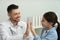 Pediatrician giving high five to little girl in hospital