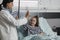 Pediatrician high fiving sick little girl under treatment resting in children healthcare facility