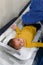 Pediatrician measuring weight of a baby boy at the doctors office for a routine checkup and physical exam to track progress at the