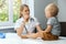 Pediatrician in office checking child throat with stick