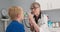 Pediatrician performing eye exam on child patient with mother in background