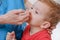 Pediatrician woman, kid boy with nose spray