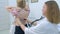 Pediatrician woman listening to heartbeat of girl using stethoscope in clinic.