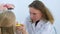 Pediatrician woman looking child girl sore throat using spatula and lantern.