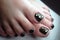 Pedicure of the foot close-up black lacquer with sequins