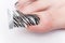 Pedicure process macro closeup. Master nail technicians apply the foil pattern to the nail
