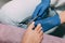 Pedicure process in salon. Foot care treatment and nail. File filing with a nail file. Master in blue gloves makes pedicure with m