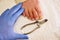 Pedicurist hands in sterile gloves cut nails and cuticles closeup . Hardware manicure.