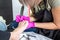 Pedicurist master in pink gloves cuts the cuticle and shellac toe nails in the pedicure salon using drill.  Professional pedicure