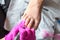 Pedicurist master in pink gloves cuts the cuticle and shellac toe nails in the pedicure salon using drill.  Professional pedicure