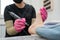 A pedicurist treats the heels of a client using a machine with an abrasive disc in a beauty salon.