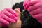 A pedicurist treats the toes of a client using a machine with an abrasive disc in a beauty salon.