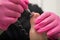 A pedicurist treats the toes of a client using a machine with an abrasive disc in a beauty salon.