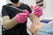 A pedicurist treats the toes of a client using a machine with an abrasive disc in a beauty salon.