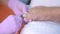 Pedicurist woman cutting toe nails using nippers in beauty salon, closeup view.