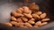 Peeled almonds falling into a dark brown wooden bowl in slow motion.