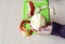 Peeled apple in girl`s hand. Apple peel on a green cutting board