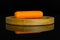 Peeled baby carrot isolated on black glass