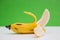 Peeled banana against green background