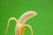 Peeled banana against green background