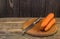 Peeled carrot with knife on a wooden table