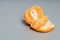 Peeled delicious orange tangerine on grey background.