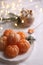 Peeled delicious ripe tangerines and glass of drink with marshmallows on white bedsheet