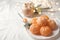 Peeled delicious ripe tangerines and glass of drink with marshmallows on white bedsheet. Space for text