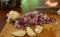 Peeled garlic and choped red onion on a rustic wooden board