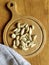 Peeled garlic cloves on chopping board and gray linen towel on old wooden background. Concept of cooking and folk medicine