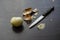 Peeled onion, husk and knife on a dark background